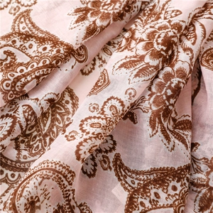 Detailed close-up of pink paisley print scarf fabric with soft linen texture and fringes