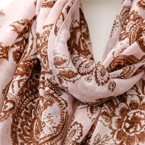 Detailed texture of pink paisley cotton scarf with delicate vintage floral patterns