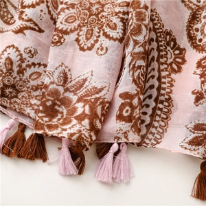 Detail of pink bohemian scarf with paisley print and matching tassel fringe accents