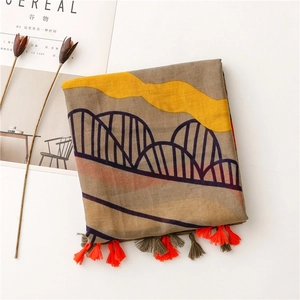 Detailed close-up of brown earth tone scarf with yellow waves and colorful fringe tassels