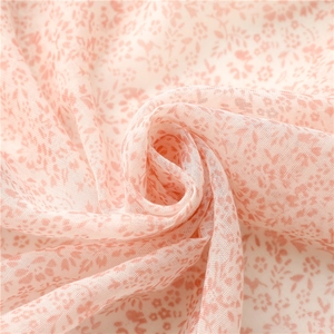 Gros plan sur le tissu en mousseline à fleurs roses et sa texture légère