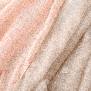 Gros plan sur la texture du tissu en mousseline fleurie, options rose et marron