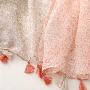 Détail de foulards légers à fleurs avec de délicats pompons et un tissu doux et fin