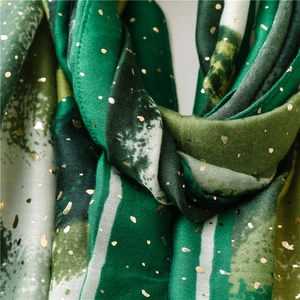Macro detail of forest green linen-feel scarf featuring elegant gold foil printing