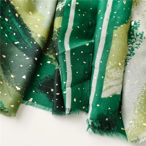 Detail of green scarf featuring metallic gold foil hearts and textured fringe edges