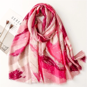 Detail of soft cotton-linen scarf with golden foil leaf print and fringed edges