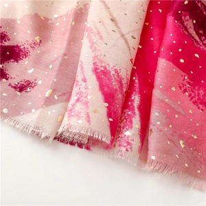 Detail of pink cotton scarf with metallic gold foil and soft frayed edges texture