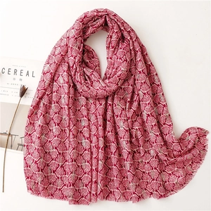 Detailed macro view of rose red linen scarf with white feather patterns and fringe edge