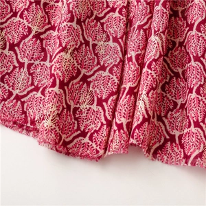 Close-up of soft cotton-linen scarf with red leaf pattern and gold foil printing details