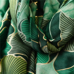 Close-up of green leaf patterns with gold foil outlines on vintage warm shawl scarf