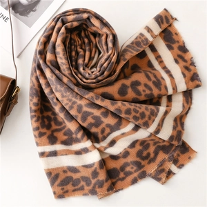 Detailed close-up of thick leopard print cashmere-like scarf with fringe and stripes