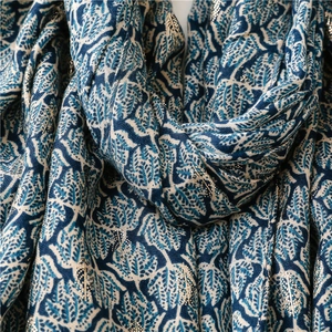Macro detail of navy scarf fabric featuring golden foil floral leaf texture prints