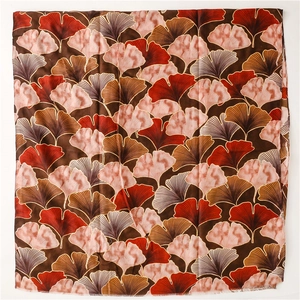 Close-up of golden ginkgo leaf patterns on a vintage thick cotton linen winter scarf