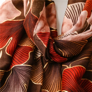 Detailed texture of cotton linen scarf featuring elegant gold foil ginkgo leaf pattern