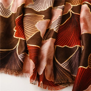Macro detail of retro ginkgo pattern scarf with gold foil accents and hand-frayed edges