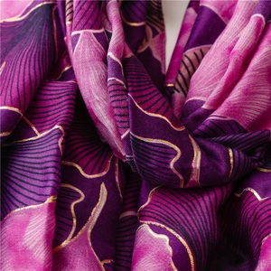 Close-up of vintage cotton-linen scarf with golden ginkgo pattern and soft fabric texture