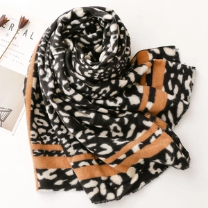 Detail of leopard print cashmere scarf with orange stripes and fringe edges