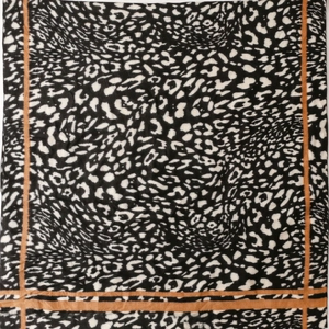 Detail of leopard print scarf with black and white patterns and brown striped borders