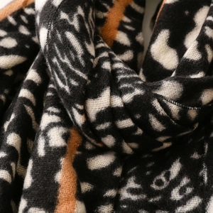 Close-up of thick cashmere-like scarf showing luxury knit texture and leopard pattern