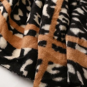 Macro detail of thick leopard print scarf featuring bright orange stripes and soft woven texture