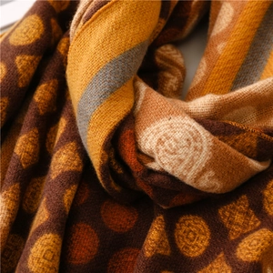 Close-up of thick cashmere-like scarf with vintage geometric and dot patterns in warm brown