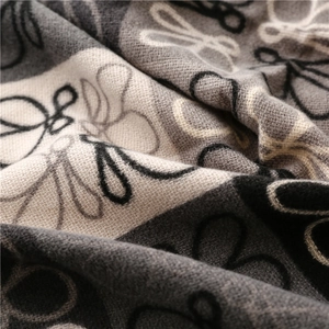 Macro shot of thick knitted cashmere scarf texture with abstract black and white floral patterns