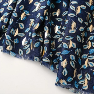 Detail of navy scarf with gold foil leaf print and soft frayed tassel edges
