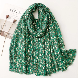 Dark green scarf with golden leaf patterns and soft fringe on white background