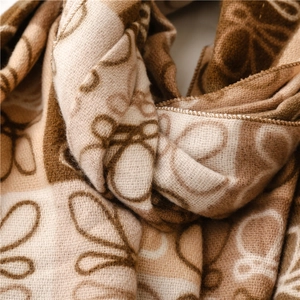 Close-up detail of soft faux cashmere scarf showing thick knit texture and floral pattern