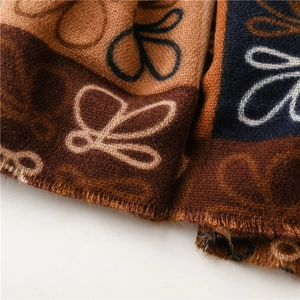 Detailed close-up of retro butterfly patterns and fringe on a thick cashmere-like scarf