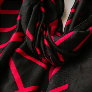 Close-up of red and black geometric pattern on soft silk-touch fashion scarf fabric