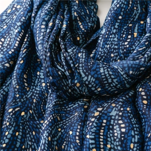 Détail d'une écharpe bleu foncé en coton et lin avec dorure et motifs texturés