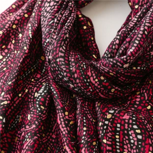 Détail d'une écharpe d'hiver avec pois colorés et élégants accents de dorure à la feuille