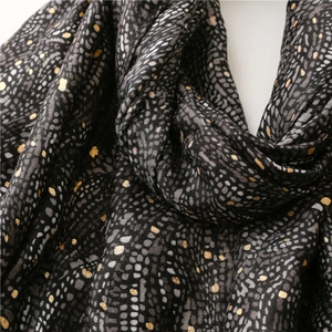 Détail de l'écharpe douce en coton et lin avec pois dorés et motif abstrait gris