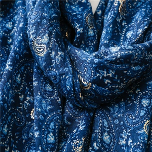 Close-up of navy paisley pattern scarf with gold foil printing and textured fabric