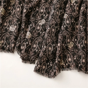 Detail of vintage paisley pattern with gold jacquard and fringe edges on warm winter shawl