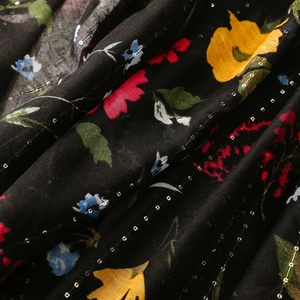 Detail of floral printed fabric with silver lurex stripes and colorful flower patterns
