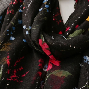 Close-up of floral print on black cotton-linen scarf with silver sequins and embroidery