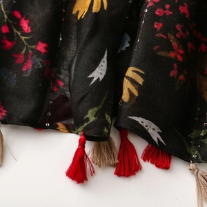 Close-up of ethnic floral scarf with sequins and decorative red tassels