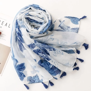 Blue and white floral cotton linen scarf with tassels in a minimalist flat lay