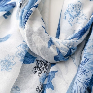 Detail of floral and butterfly print on breathable cotton-linen textured blue white scarf