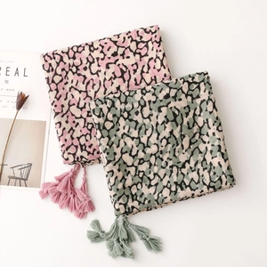Detail of leopard print scarves featuring tassels and cotton-linen texture