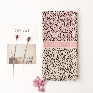 Detail of pink leopard print scarf with LOVE letter ribbon and soft fringe accents