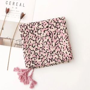 Detail of leopard print scarf with pink tassels and cotton-linen texture on white background