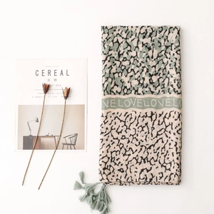 Detail of leopard print scarf with LOVE letter pattern and soft light green fringe
