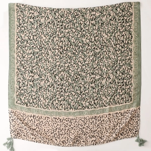 Close-up of olive green leopard print scarf with LOVE text border and tassel details