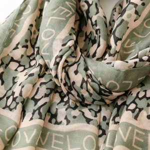 Detail showing the leopard print and love letter patterns on a soft cotton scarf