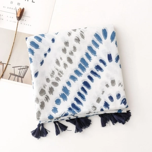 Detail eines Baumwollschals mit blauen Batik-Punkten und Quasten am Rand