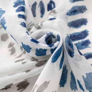 Detailansicht eines weichen, atmungsaktiven Stoffes mit blau-grauen künstlerischen Pinselstrichen
