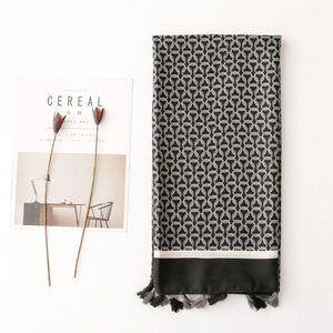 Detail of herringbone pattern shawl with chic tassel trim and geometric print design